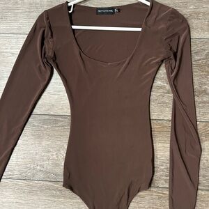 Smooth, fitted brown long-sleeved thong bodysuit. Snap closure at bottom.